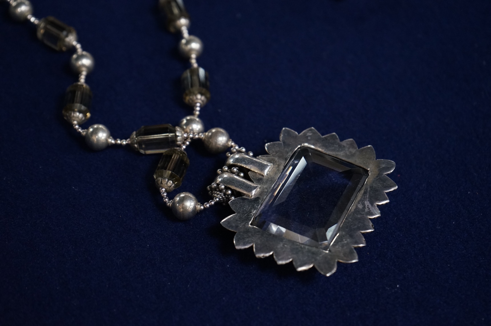 A white metal and quartz set drop pendant necklace, overall 90cm.